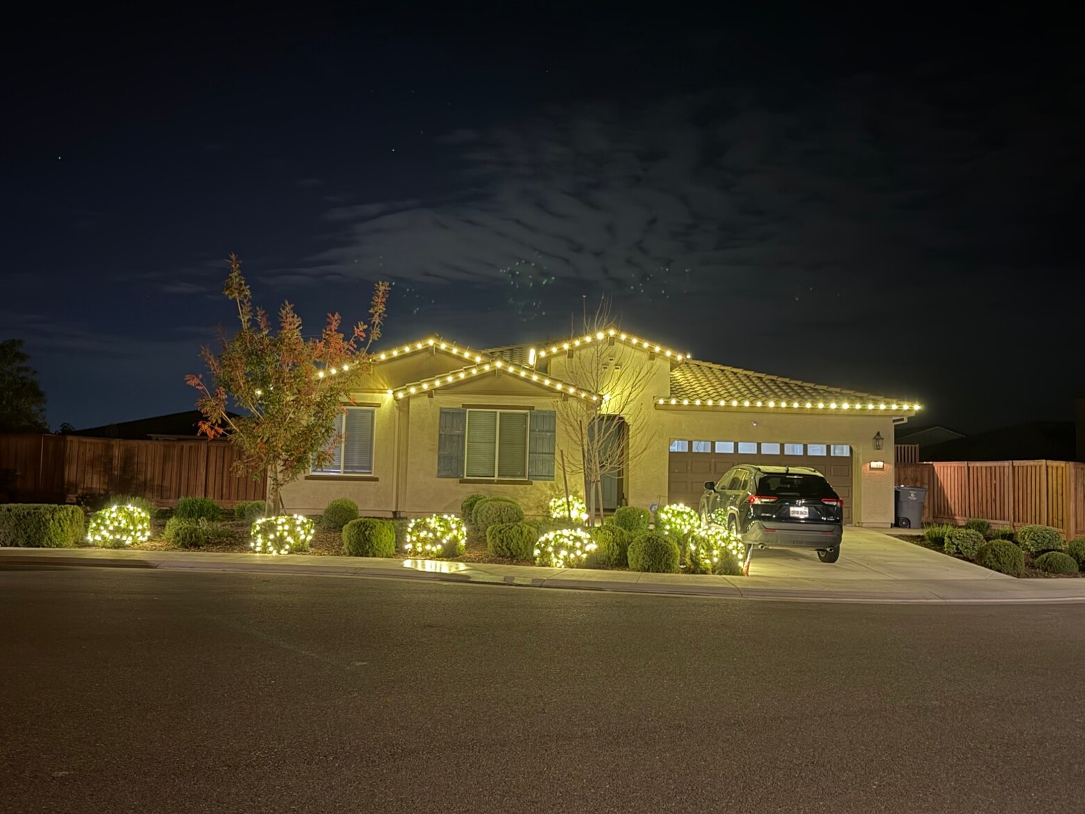 Christmas light installation in Roseville, CA: single story stucco warm white roofline lit shrubs